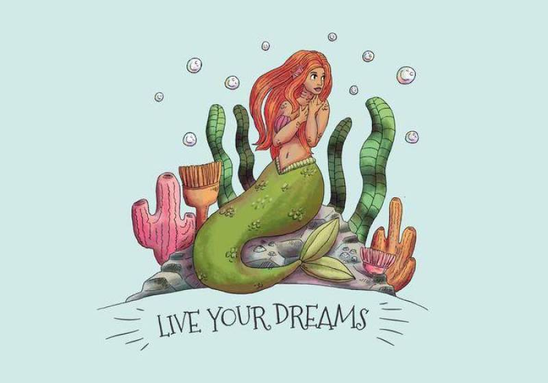 坐在与海草和珊瑚的石头的逗人喜爱的美人鱼