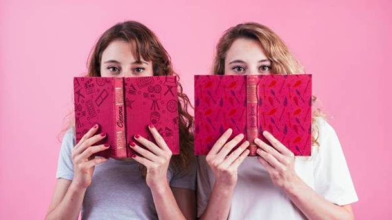 Young girls holding book cover mockup
