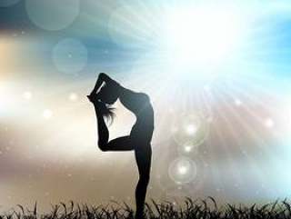 一位女性在瑜伽姿势在阳光明媚的风景的剪影
